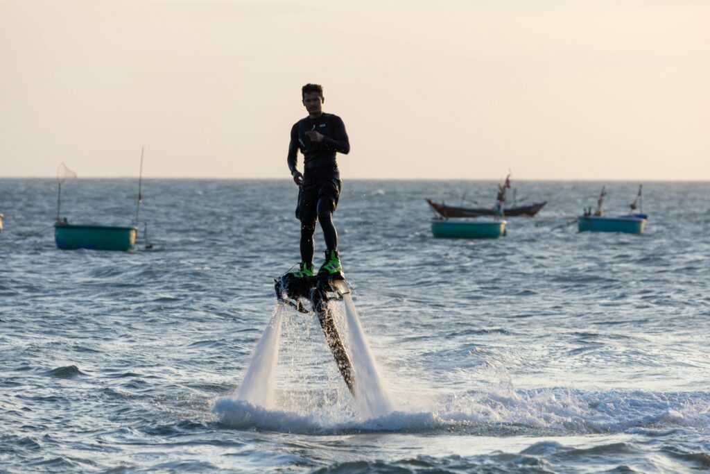 Man enjoying flyboarding on the ocean creating an exhilarating water sports experience.