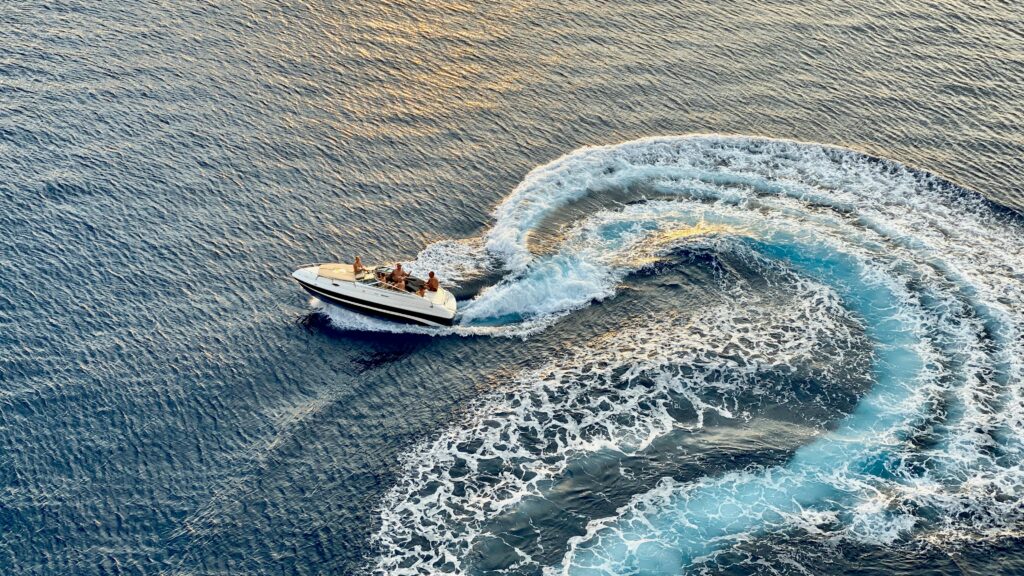 Experience the thrill of a speedboat creating dynamic waves in the Caribbean Sea off Aruba's coast.