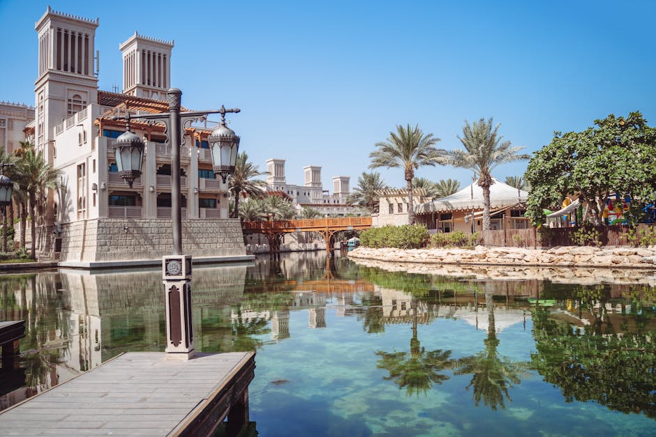 Explore the serene setting of Madinat Jumeirah Resort in Dubai, featuring traditional architecture and lush palm trees.